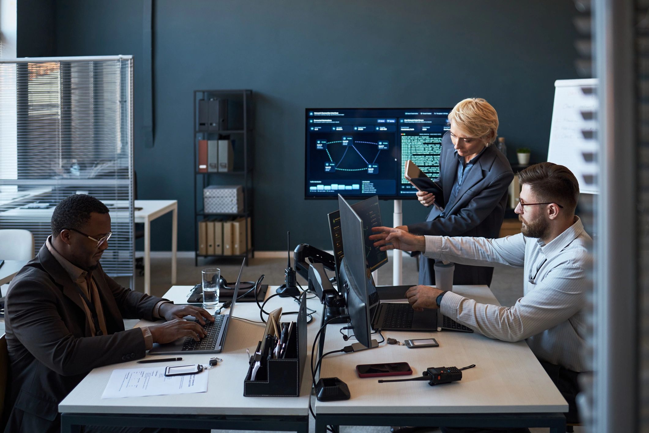 Team reviewing monitoring and technology systems in an office environment